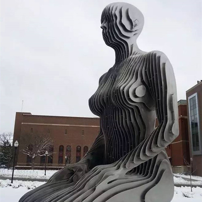 消える抽象的な装飾的な金属の女性図の芸術の彫刻に座っています